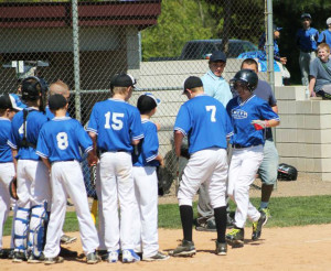 (Photo by Monica Goheen) Skylar Rhoades being greeted by the B&W Smith team after hitting a home run against Grand Valley