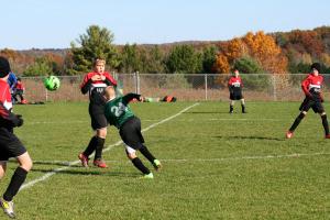 Austin Coull heads the ball in a sea of red against Meadville